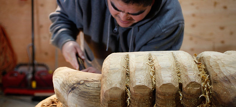 Musqueam artist Brent Sparrow Jr. carved the new Musqueam Post during UBC’s Centennial year. Photo credit: Reese Muntean